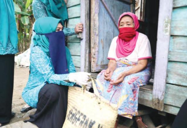 BAGIKAN SEMBAKO: Ketua Tim Penggerak Pemberdayaan Kesejahteraan Keluarga (TP-PKK) Kabupaten Tanah Bumbu Hj Sadariah membagikan sembako kepada warga Kecamatan Simpang Empat yang terdampak Covid-19.