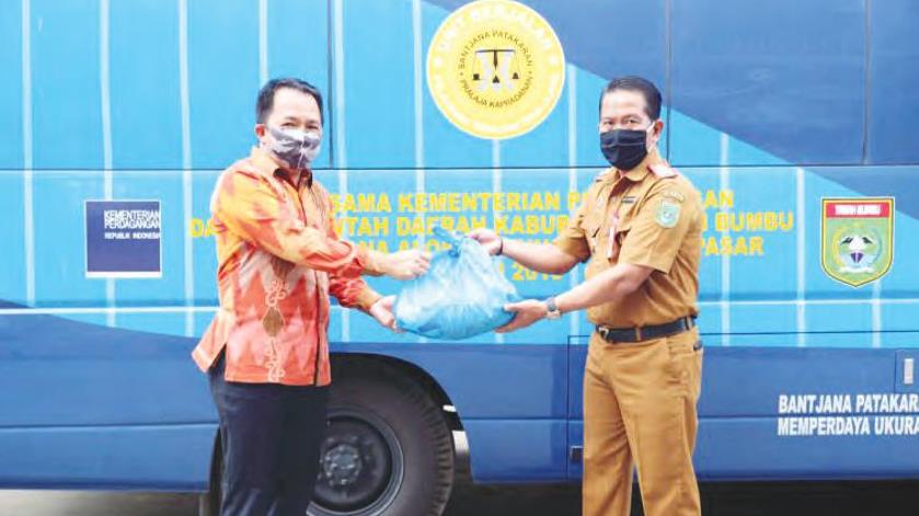 SERAHKAN SEMBAKO: Bupati Tanah Bumbu H Sudian Noor (kiri) menyerahkan secara simbolis bantuan berupa sembako kepada masyarakat yang diterima Kepala Dinas Perdagangan dan Industri (Kadisdagri) Tanbu H Deny Harianto di kediaman Bupati Tanbu, Senin (4/5)