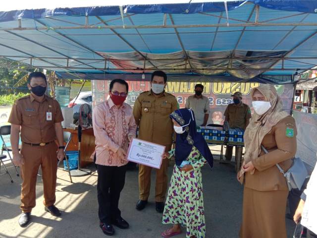 SERAHKAN BLT: Bupati Tanbu H Sudian Noor menyerahkan BLT kepada warga Desa Saring Sungai Binjai Kecamatan Kusan Hilir. (Foto Diskominfo Tanbu For Radar Banjarmasin).