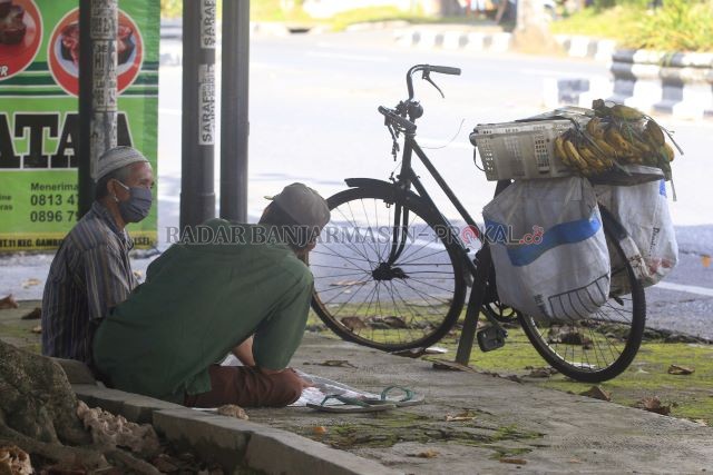 SITUASI SULIT: Dua warga berbincang sembari menunggu jualan pisang. Pandemi Covid-19 membuat roda perekonomian jadi seret, dari data Dinas Sosial Kota Banjarbaru ada kurang lebih 4000 KK yang muncul sebagai kategori keluarga miskin baru selama pandemi ini