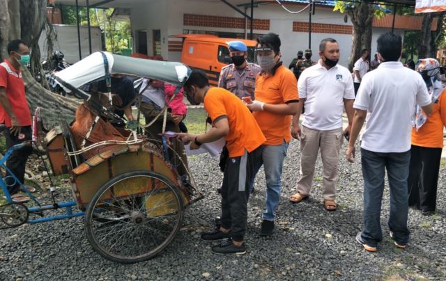 PENERIMA MANFAAT: Distribusi dana BST di Kantor Pos Amuntai, Sabtu (9/5) tadi. Proses distribusi ini dikawal dan diawasi langsung aparat kepolisian.