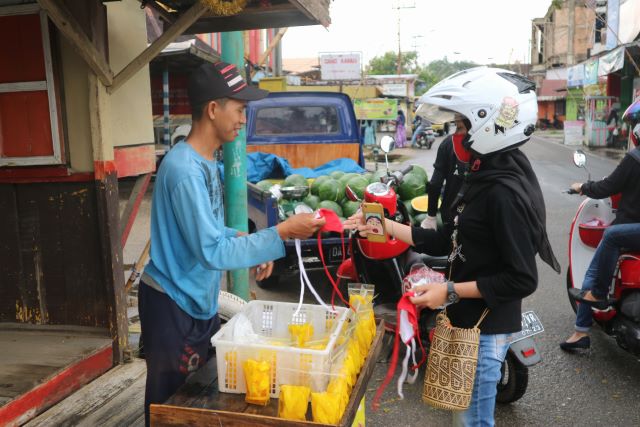AKSI PEDULI: Salah satu pedagang di Jalan Tasan Panyi Kecamatan Tapin Utara mendapatkan masker. | Foto: Rasidi Fadli/Radar Banjarmasin