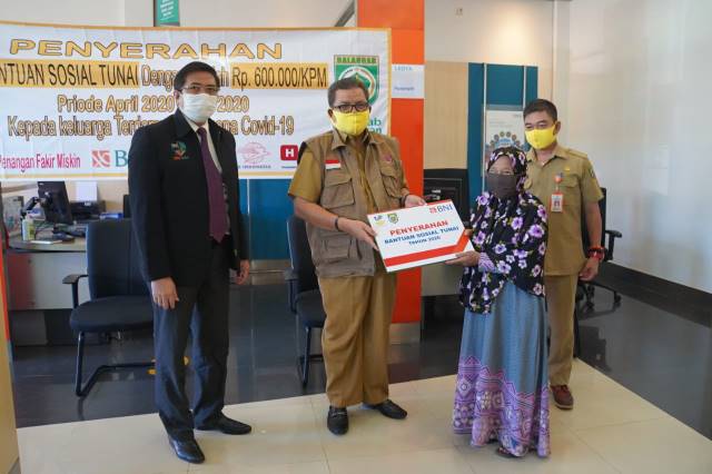 SIMBOLIS: Bupati Balangan Ansharuddin (kiri) saat secara simbolis menyalurkan BLT Kemensos ke penerima. | FOTO: WAHYUDI/RADAR BANJARMASIN.