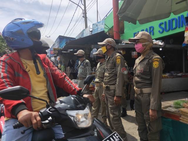 JAMIN PERSUASIF: Satpol PP ketika mendatangi Pasar Sudimampir, kemarin (12/5). Aksi itu tentu saja menyedot perhatian pedagang dan pembeli. | FOTO: FAHRIADI NUR/RADAR BANJARMASIN