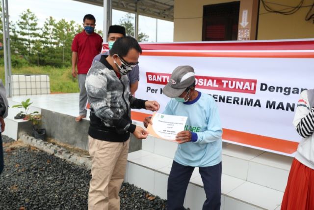 SERAHKAN BST: Bupati Tanah Bumbu menyerahkan secara simbolis Bantuan Sosial Tunai (BST) dari Kementerian Sosial Republik Indonesia bagi warga terdampak pandemi Covid-19 di Desa Sukamaju Kecamatan Batulicin, Minggu (10/5). (Foto Diskominfo Tanbu For Radar