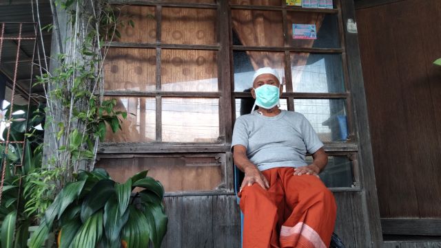 TABAH: M Alwi berkisah kepada wartawan di pelataran rumahnya di Desa Hilir. Kakek usia 73 tahun ini dinyatakan sembuh dari corona pada 7 Mei tadi.