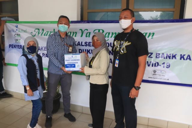 PEDULI: Jajaran Bank Kalsel Cabang Banjarbaru saat menyerahkan bantuan paket sembako kepada perwakilan jurnalis Banjarbaru, Rini Maskanari dan Kepala Bagian Humas dan Protokol Pemko Banjarbaru Dedy Sutoyo (kaos hitam), Jumat (15/5) tadi. | FOTO: HUMAS DAN