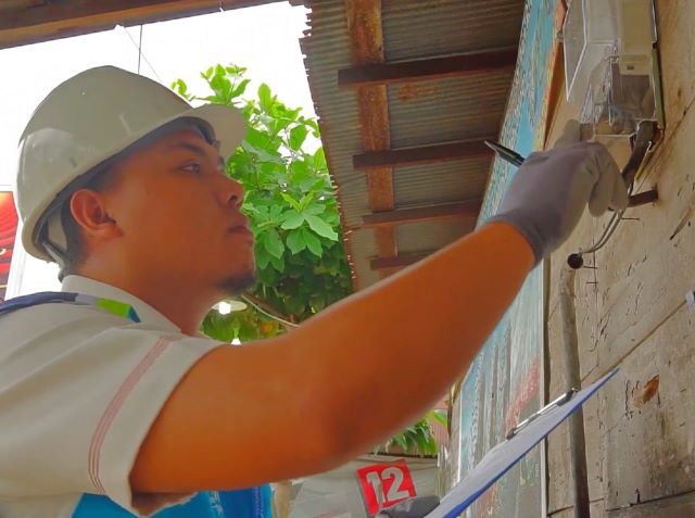 PENCATATAN: Petugas PLN melakukan pencatatan meter di rumah pelanggan.