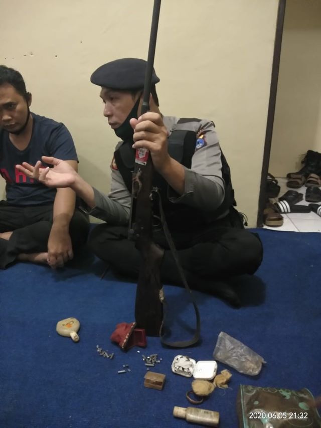 BARANG BUKTI: Salah seorang anggota Polsek Jaro memagang senpi milik pelaku pencurian di Desa Muang.