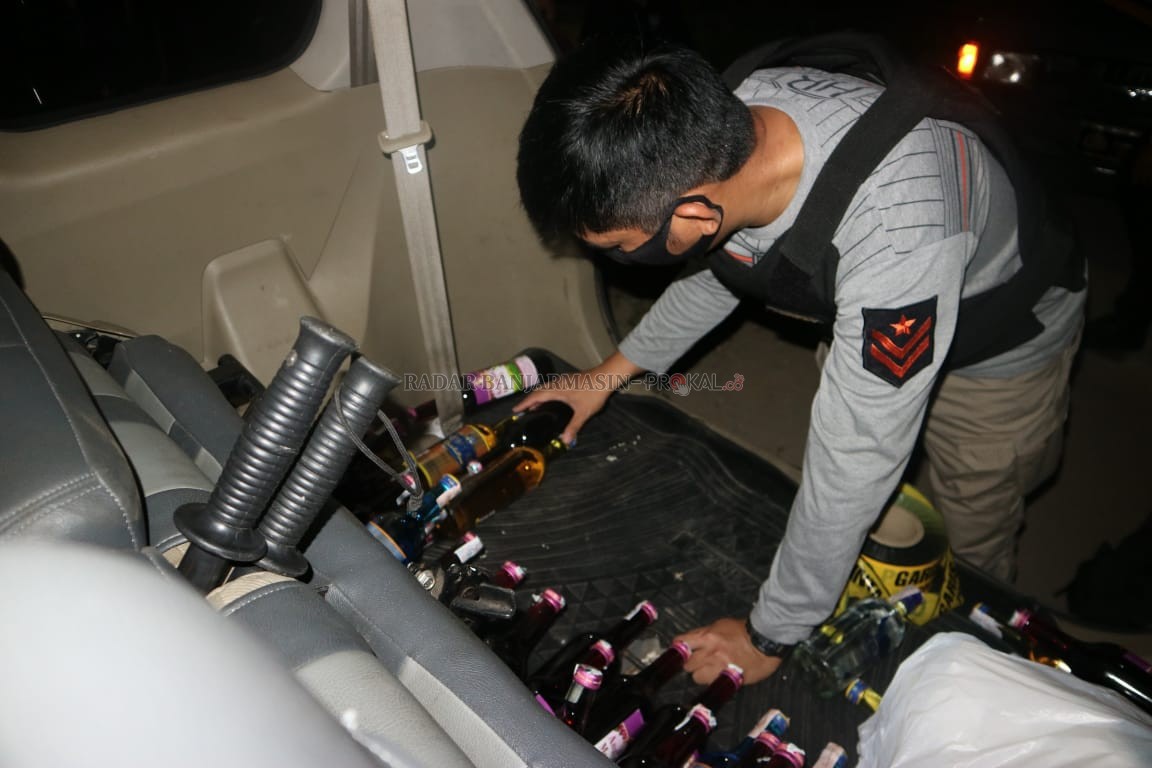 BARANG BUKTI; Kapolsek Tapin Utara, Ipda Subroto Rindang Ari Setyawan, menyusun barang bukti minuman keras yang diamankan dimobilnya. | Foto: Rasidi Fadli/Radar Banjarmasin