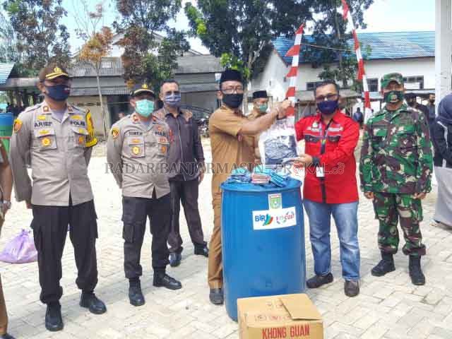 BANTUAN: Penyerahan bantuan tong air dan APD dari PT BIR kepada Kepala Desa Mekar Jaya Wiyono Setiawan. | Foto: Karyono/Radar Banjarmasin