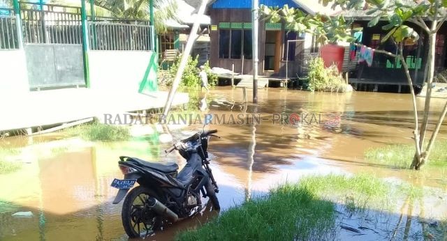 TERENDAM: Akses jalan Desa Pantai Harapan, Tanah Laut terendam banjir rob. Banjir tahunan ini mengakibatkan warga sulit beraktivitas. | FOTO: ARDIAN HAIRIANSYAH/RADAR BANJARMASIN