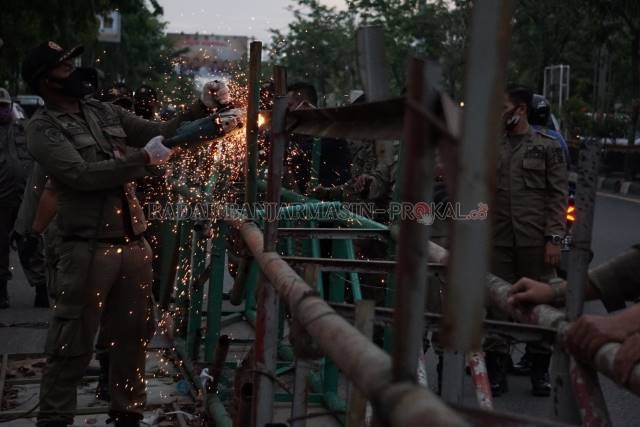 BONGKAR: Petugas satpol PP Kota Banjarmasin, ketika membereskan puing-puing bando di kawasan jalan A Yani Banjarmasin beberapa waktu lalu. | FOTO: WAHYU RAMADHAN/RADAR BANJARMASIN