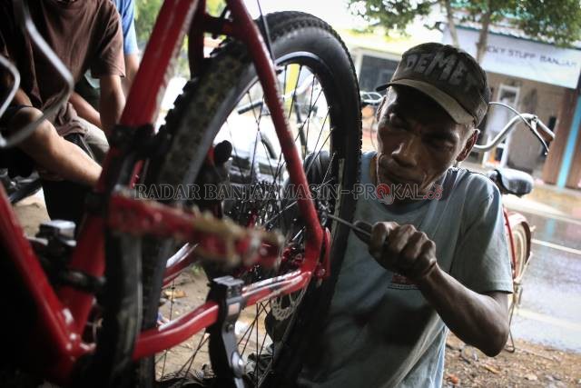 KECIPRATAN TREN: Supar, mekanik di bengkel Sepeda Demet 064 di Jalan Kebun Karet mengerjakan perbaikan salah satu unit sepeda milik konsumennya. Selama tren sepeda ramai, bengkel sepeda di Banjarbaru juga kebanjiran orderan. | FOTO: MUHAMMAD RIFANI/RADAR