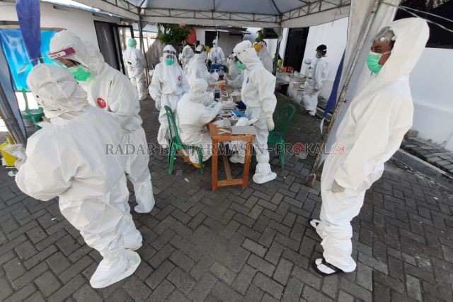 BERGUGURAN: Petugas kesehatan mengenakan hazmat di halaman kantor Dinas Kesehatan Banjarmasin. Dalam swab test beberapa waktu lalu. | FOTO: WAHYU RAMADHAN/RADAR BANJARMASIN