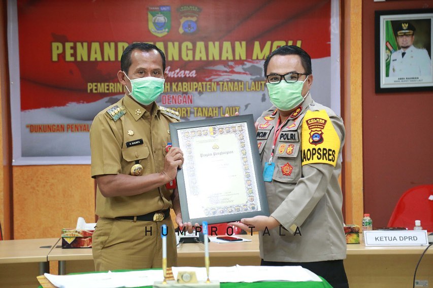 PENGHARGAAN: Bupati Tala Sukamta menerima penghargaan dari Polda Kalsel terkait sinergisitas penanggulangan Pandemi Covid-19 di area Pemkab Tala yang diserahkan Kapolres Tala AKBP Cuncun Kurniadi. (Humas for Radar Banjarmasin)