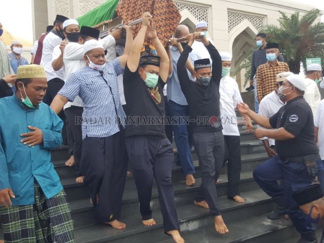 BAKTI ANAK: Haji Isam (kaos hitam) menggotong keranda berisi jenazah ayahnya dari Masjid Agung Al-Falah Batulicin. | FOTO: KARYONO/RADAR BANJARMASIN