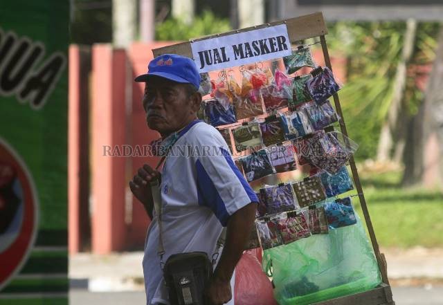 MASKER: Seorang pria renta memilih berjualan masker di sekitaran Jalan A Yani Banjarbaru. Pemko Banjarbaru menerbitkan Perwali soal pengenaan sanksi sekaligus denda bagi yang melanggar protokol kesehatan, termasuk tidak mengenakan masker. Perwali ini jadi