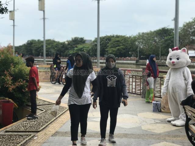 TAK DISIPLIN: Tanpa masker, warga dengan santai melenggang di Siring Sudirman pada akhir pekan tadi. Hati-hati karena ke depan bakal ada sanksi denda. | FOTO: WAHYU RAMADHAN/RADAR BANJARMASIN
