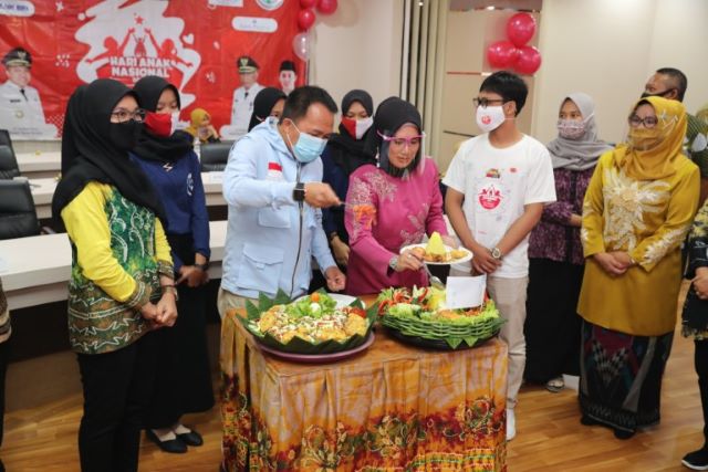 POTONG TUMPENG: Bupati Tanbu H Sudian Noor melakukan pemotongan nasi tumpeng yang diserahkan kepada Ketua TP-PKK Tanbu Hj Sadariah.