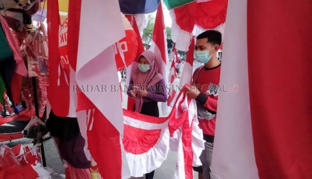 MERAH PUTIH: Pembeli memilih bendera dan umbul-umbul di Taman Sari. Menjelang perayaan 17 Agustus, kawasan ini berubah menjadi lapak musiman pedagang bendera. | FOTO: ENDANG SYARIFUDDIN/RADAR BANJARMASIN