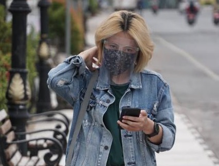 PELINDUNG: Seorang remaja di Banjarmasin jalan dengan masker dan tameng wajah. | FOTO: WAHYU RAMADHAN/RADAR BANJARMASIN