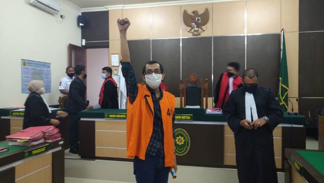 BERSEMANGAT: Diananta Sumedi  mengepalkan tangan kepada wartawan usai sidang vonis di PN Kotabaru, Senin (10/8). | FOTO: ZALYAN SHODIQIN ABDI/RADAR BANJARMASIN