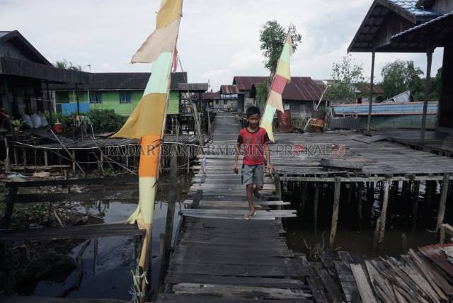 HARAPAN: Penduduk Pulau Bromo berharap titian sebagai akses utama mereka bisa diperbaiki pemko. Delta ini berada di perbatasan Kota Banjarmasin dan Kabupaten Banjar. Foto diambil Minggu (16/8) siang. | FOTO: WAHYU RAMADHAN/RADAR BANJARMASIN