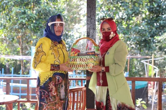 SERAHKAN BINGKISAN: Ketua TP-PKK Tanbu Hj Sadariah (kanan) menyerahkan bingkisan kepada Ketua TP-PKK Kotabaru Hj Fatma Idiana Sayed.