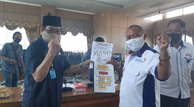 TUNTUTAN BURUH: Anggota DPRD Kalsel, Karli Hanafi menerima surat tuntutan dari perwakilan Aliansi PBB Kalsel, Yoeyoen Indharto. | FOTO: ENDANG S/RADAR BANJARMASIN
