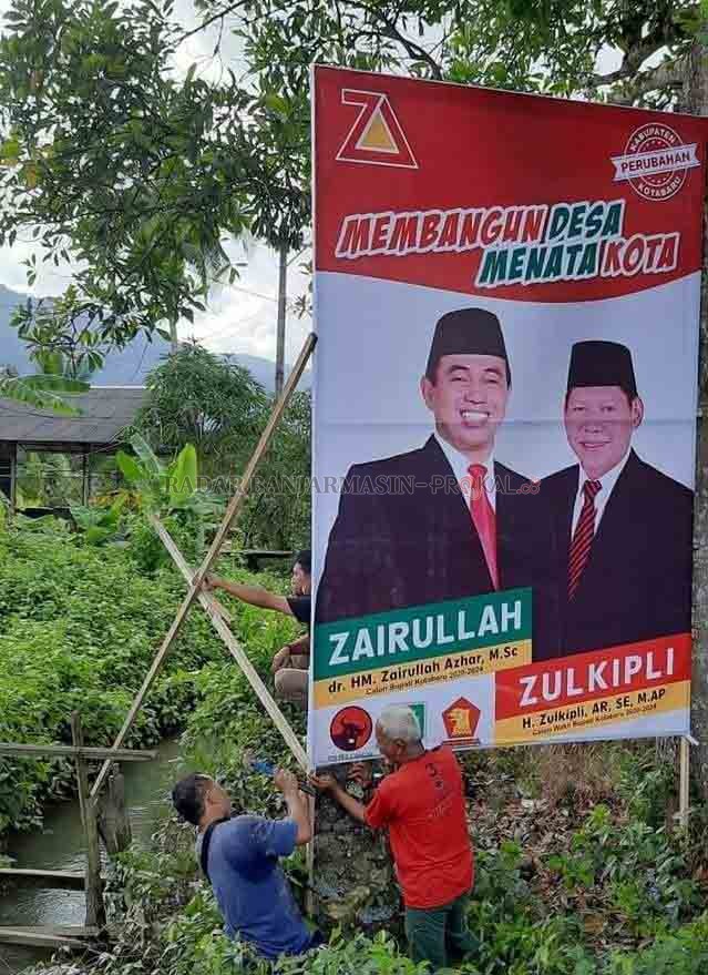 MUNDUR:  Para relawan memasang baliho Zairullah - Zulkifli di Kotabaru, beberapa waktu lalu. | FOTO: ZALYAN S ABDI/RADAR  BANJARMASIN