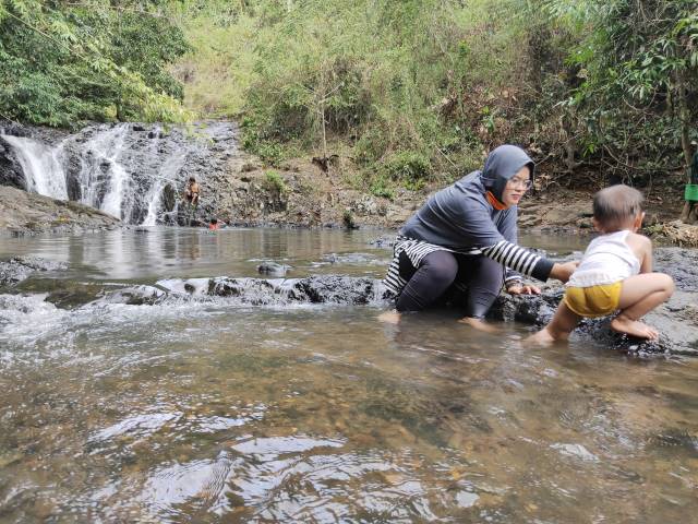 AIR TERJUN: Beberapa keluarga membawa anak-anaknya bermain di objek wisata air terjun Hangui.