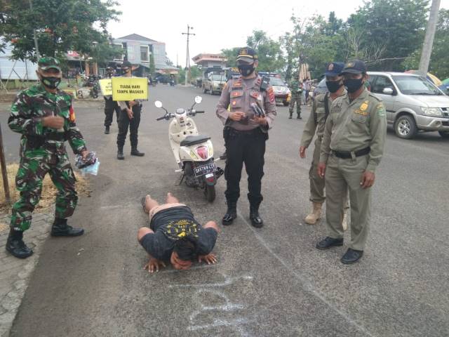 TINDAKAN: Salah satu warga menerima hukuman push up, setelah tidak memakai masker saat beraktivitas di pasar Keraton Rantau. | Foto: Polsek Tapin Utara for Radar Banjarmasin