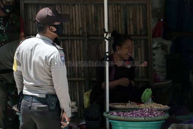 ADA-ADA SAJA: Ketika ditegur petugas untuk segera mengenakan masker, pedagang di kawasan Sentra antasari ini malah tertawa. | Foto: Wahyu Ramadhan/Radar Banjarmasin