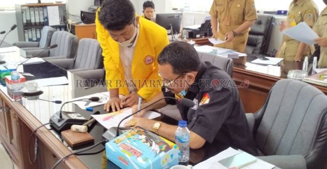 TEKEN BUKTI: Mahasiswa menyodorkan nota kesepahaman untuk diteken Ketua DPRD Kalsel, Supian HK. Agar ada bukti bahwa dewan akan menindaklanjuti tuntutan mahasiswa, tak sekadar mendengarkan. | Foto: Endang/Radar Banjarmasin
