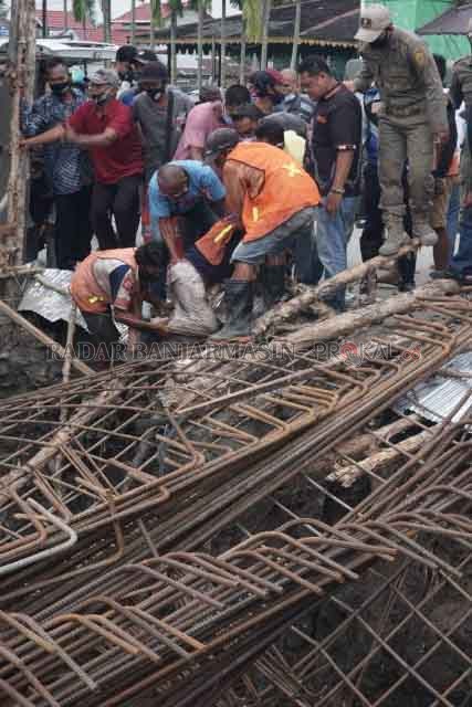 EVAKUASI: Pekerja proyek terjebak di bawah reruntuhan rangka besi jembatan. Aparat dan warga tolong-menolong selama evakuasi. | FOTO: WAHYU RAMADHAN/RADAR BANJARMASIN