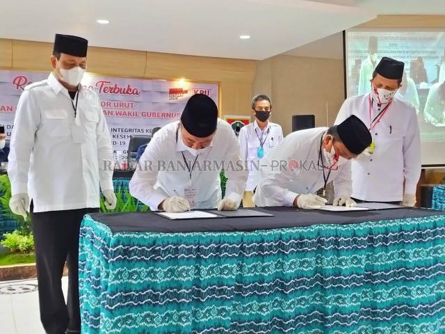 EFEKTIFKAN MEDSOS: Sahbirin Noor-Muhidin dan Denny Indrayana-Difriadi Darjat saat menandatangani deklarasi damai di KPU Kalsel, Kamis tadi. | FOTO: M OSCAR FRABY/RADAR BANJARMASIN