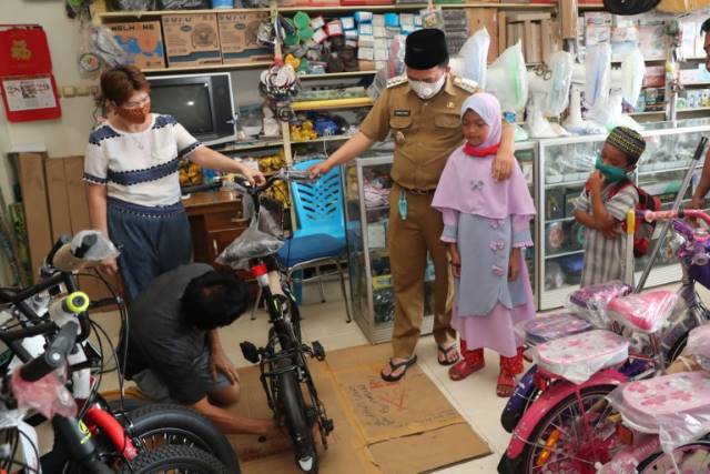 KE TOKO SEPEDA: Bupati mengajak Rahmatiah ke toko sepeda.