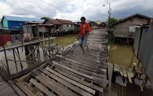 BERLUBANG DAN BERDERAK: Inilah titian ulin yang menjadi jalan lingkungan warga Antasan Bondan. Jaraknya sekitar 8 kilometer saja dari kantor wali kota. | FOTO: WAHYU RAMADHAN/RADAR BANJARMASIN