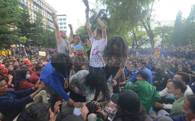 TEATRIKAL: Mahasiswa menampilkan aksi teatrikal. Sebagai sindiran kepada penguasa yang hobi menindas rakyat. Foto diambil di Jalan Lambung Mangkurat. Demonstran gagal mendekati gedung DPRD Kalsel  karena dikawal ketat aparat. | FOTO: WAHYU RAMADHAN/RADAR