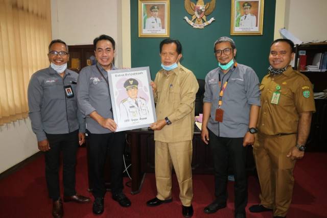 FOTO BERSAMA: Direktur Radar Banjarmasin menyerahkan cendera mata kepada Bupati Tapin M Arifin Arpan.
