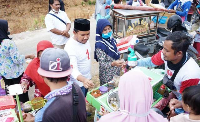 CAWABUP : Cawabup Tanbu Muh Alpiya Rakhman (kaos putih) makan pentol sambil mengajak ngobrol warga.