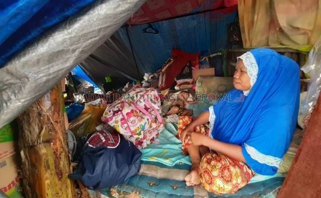 PRIHATIN: Ratna menjaga anaknya yang kecil di tenda darurat sumbangan dermawan. | FOTO: WAHYU RAMADHAN/RADAR BANJARMASIN