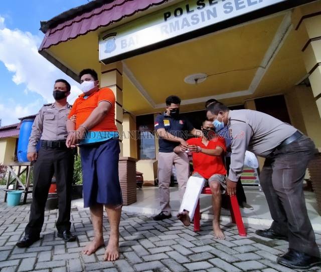 SUNGGUH TEGA: Herman (berdiri) dan Jailani (duduk) ketika dihadirkan di depan Mapolsek Banjarmasin Selatan, kemarin (11/11) sore. | FOTO: MAULANA/RADAR BANJARMASIN