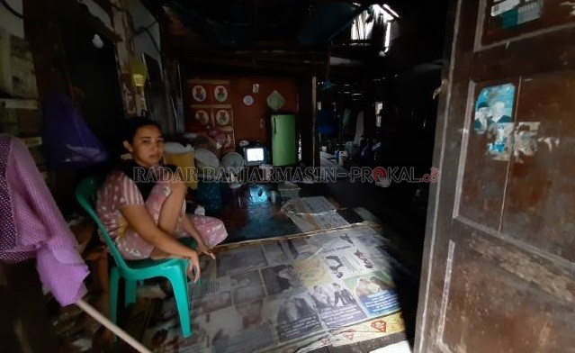 MEMBATIN: Warga Gang Bandaneira, Novia Meiliani akhirnya bisa bersantai. Setelah genangan di lantai rumahnya menyurut dan mengering | FOTO: WAHYU RAMADHAN/RADAR BANJARMASIN