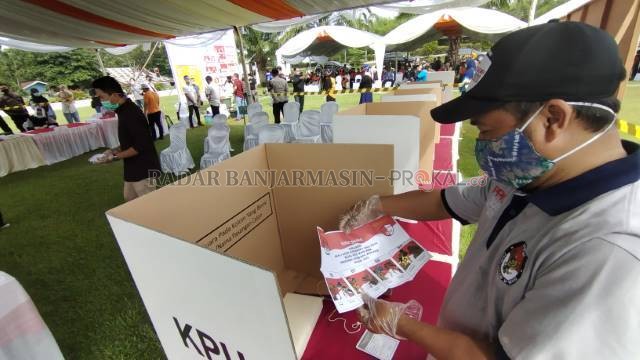 KETAT: Salah satu yang berbeda pada pencoblosan kali ini, setiap pemilih wajib menggunakan masker dan sarung tangan dari plastik yang disediakan di TPS. | FOTO: WAHYUDI/RADAR BANJARMASIN.