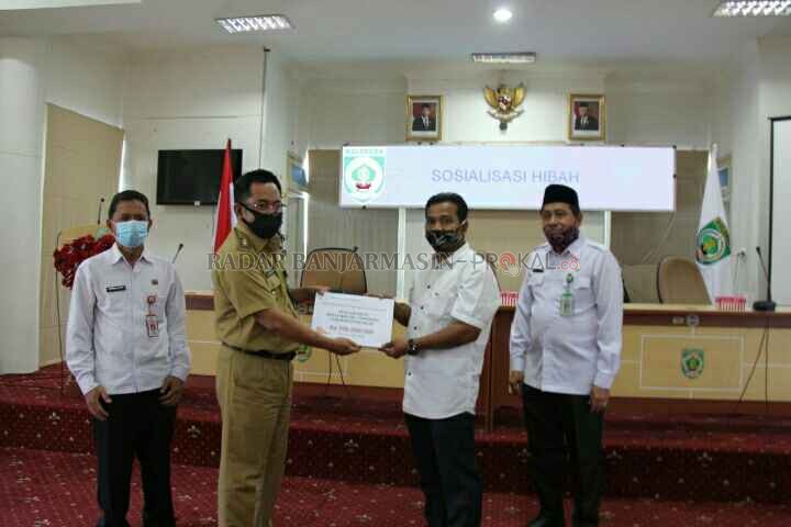 SIMBOLIS: Plt. Bupati Balangan, Syaifullah (kiri) menyerahkan dana hibah kepada perwakilan salah satu tempat ibadah. | FOTO: WAHYUDI/RADAR BANJARMASIN