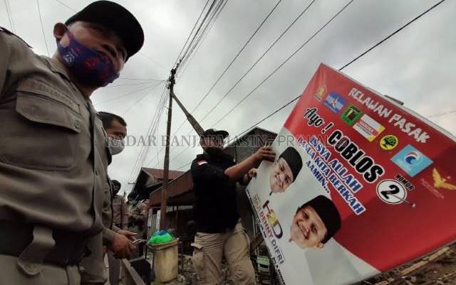 DITURUNKAN: Operasi gabungan Bawaslu dan Satpol PP membersihkan ratusan APK yang tersebar di lima kecamatan di Banjarmasin. | FOTO: WAHYU RAMADHAN/RADAR BANJARMASIN
