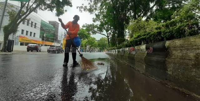 PASUKAN KUNING: Penyapu jalan Dinas Lingkungan Hidup Banjarmasin saat bekerja di Jalan Lambung Mangkurat, kemarin (2/12). | FOTO: WAHYU RAMADHAN/RADAR BANJARMASIN