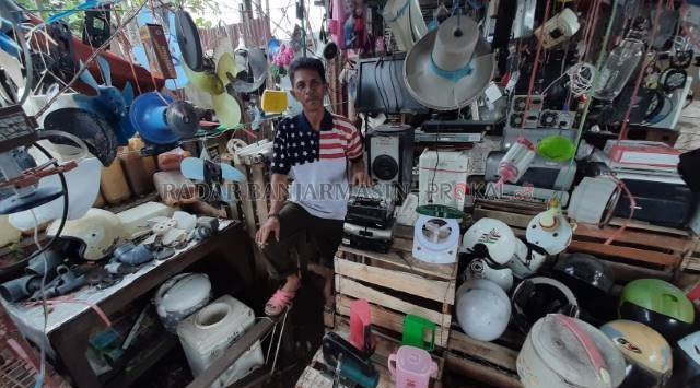 TIDAK GENGSI: Di tengah tumpukan barang bekas, Hamdani berpose untuk Radar Banjarmasin, kemarin (4/12). Kios barang loak itu menyatu dengan rumahnya di Jalan PM Noor. | FOTO: WAHYU RAMADHAN/RADAR BANJARMASIN